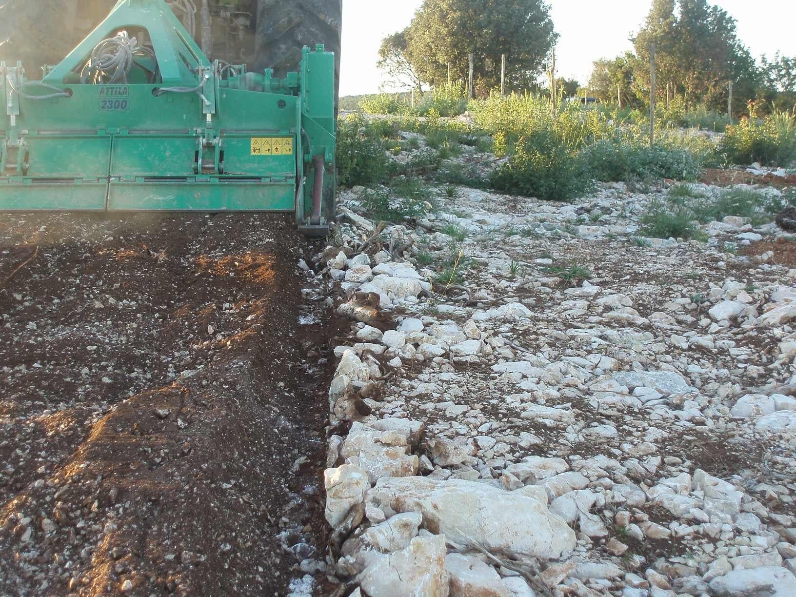 Una trituradora Valentini ATTILA 2300 partiendo el terreno en dos: a la izquierda la tierra ya molida, a la derecha la piedra caliza blanca todavía sin tocar