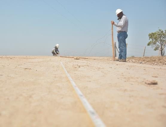 Ingeniero tomando medidas en la superficie de una obra