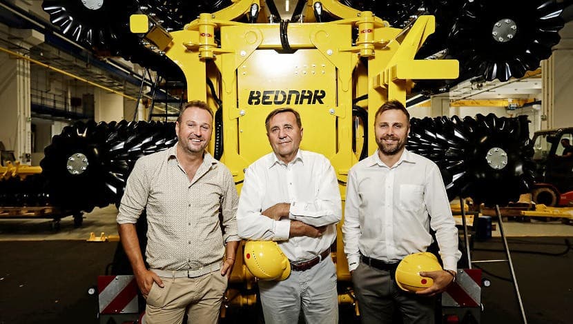 Tres directivos de BEDNAR frente a una de sus máquinas en la planta