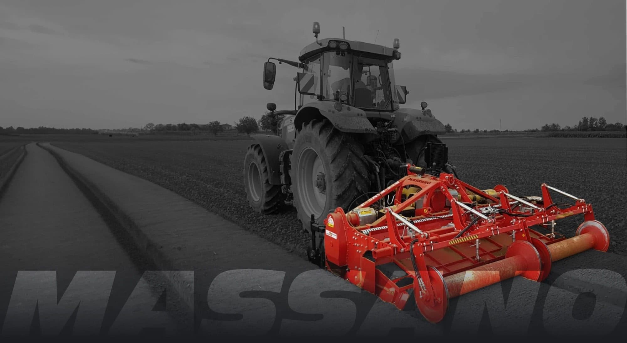 Acamadora Massano roja formando una cama junto a un campo sin trabajar, foto en blanco y negro con la máquina a color