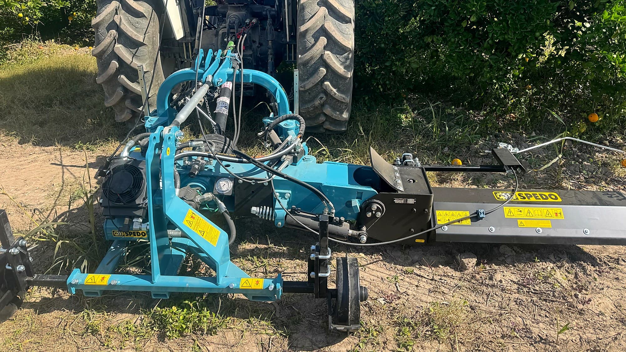 El PLUTONE de SPEDO montado al tractor en una hilera de cítricos